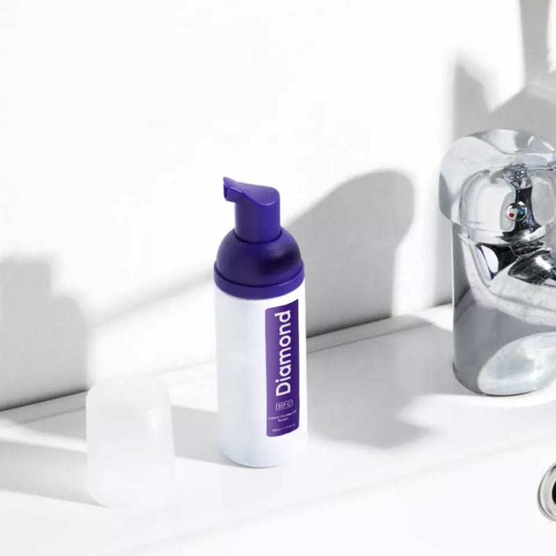 Diamond Smile violetti hampaiden valkaiseva värinkorjausvaahto valkoista taustaa vasten kylpyhuoneessa.